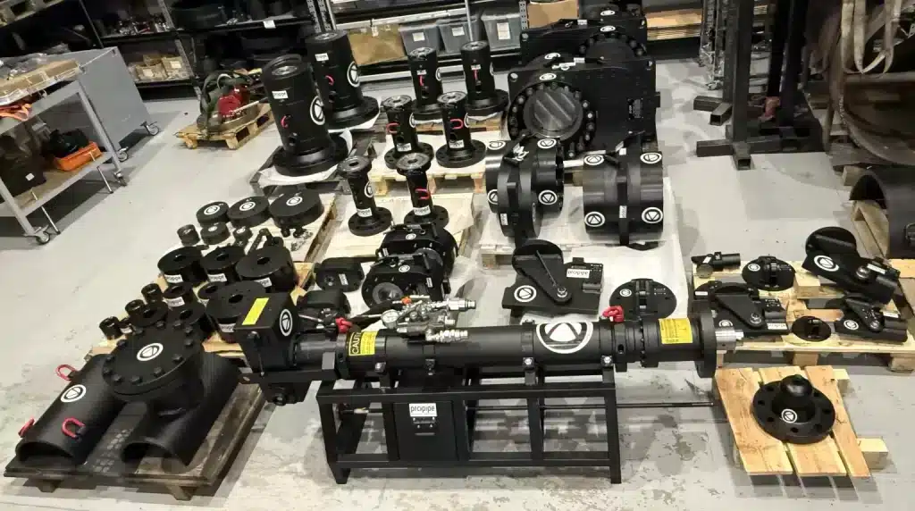 Workshop view showing a Propipe Hot Tap Machine 3000 series surrounded by various pipeline maintenance components