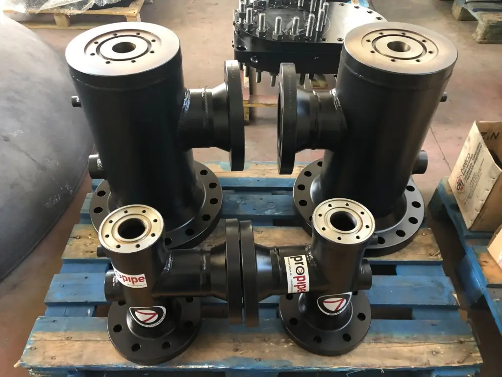 Four black Propipe line stop housings with flanged ends on a blue pallet in a warehouse